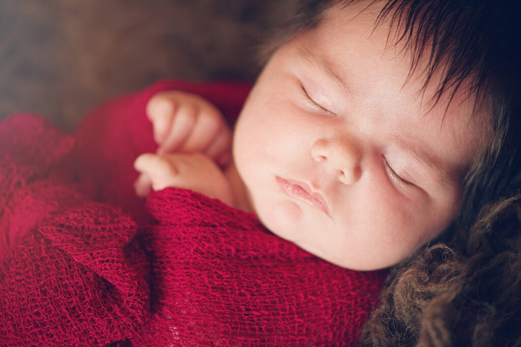 Newborn Baby in Red Gauze Wrap